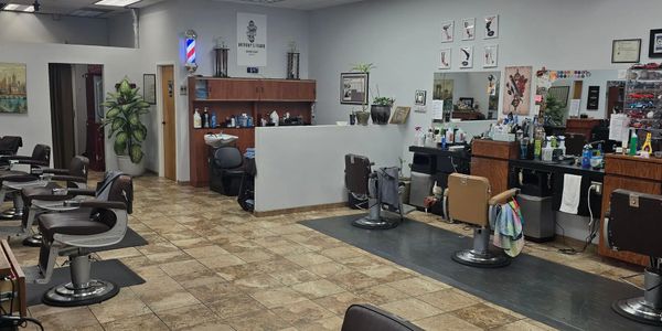 Clean and spacious barbershop with multiple styling chairs and well-organized stations.