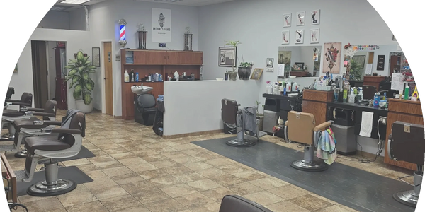 Clean and spacious barbershop with multiple styling chairs and well-organized stations.