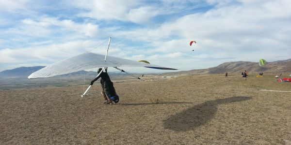 A hang glider preparing to fly with paragliders in the background at the southside of the point of the mountain near Salt Lake City Utah. 