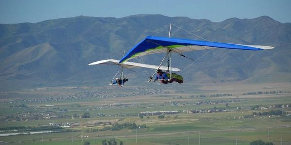 Two hang gliders flying near each other over the Salt Lake valley