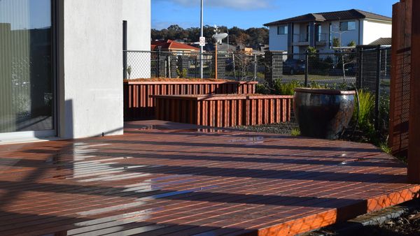 Timber deck with custom raised planters made to match with Merbau cladding