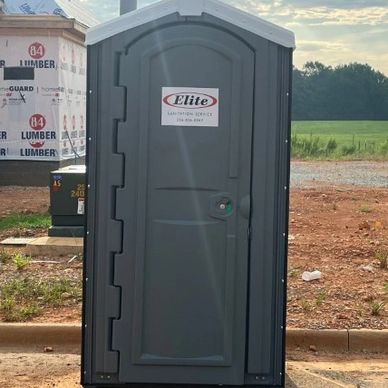 Portable restroom at a construction site during sunset.