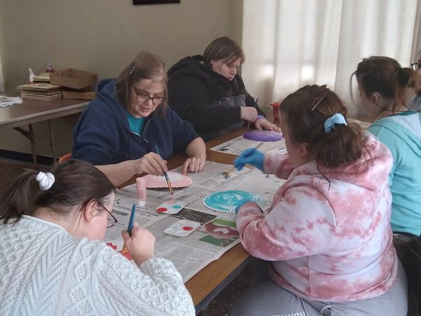 Group painting on round canvases indoors.