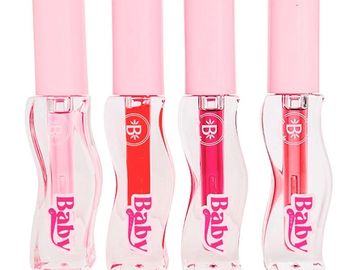 Four lip gloss tubes with pink caps and colorful shades inside.