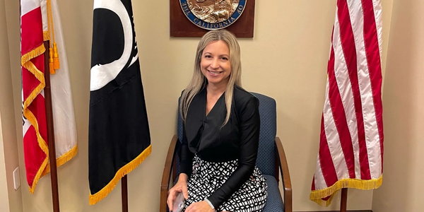 Susan sitting on a chair near flags