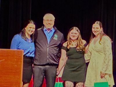 Group photo of four people on stage.