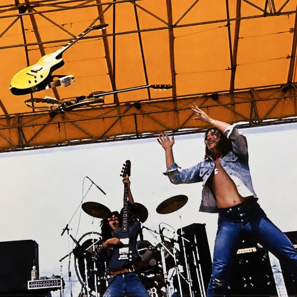 Rock band on stage with guitarist throwing guitar and dynamic vocalist.