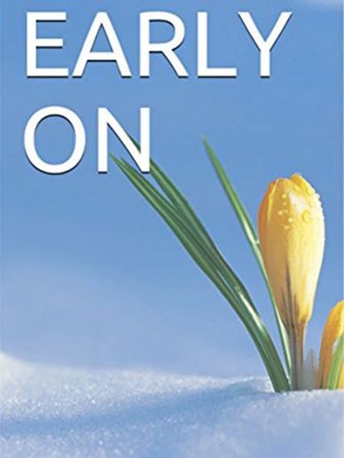 Yellow crocus flower emerging from snow under a clear blue sky.