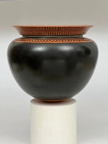 Base is black. Shoulder & neck is decorated with fishes & seaweeds. Black-figure wine mixing vessel.