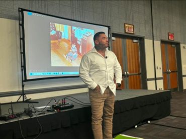 Man in white shirt presenting with a childhood photo projected behind him.