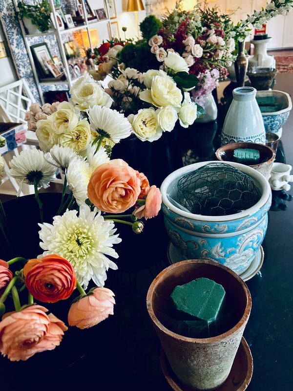 Various flowers and planting supplies arranged on a dark table indoors.