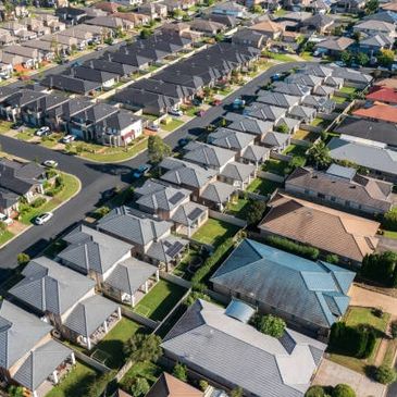 Aerial view of a suburban neighborhood with rows of houses and streets.