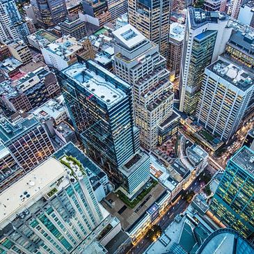 Aerial view of a dense cityscape with tall buildings and busy streets.