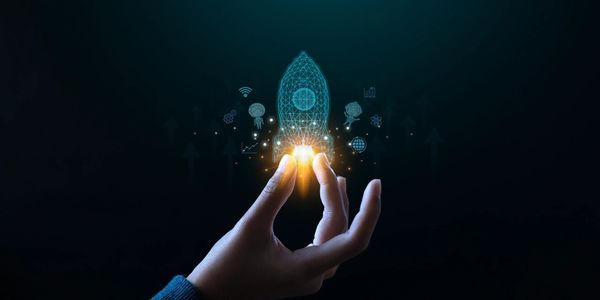 Hand holding a glowing digital rocket symbolizing innovation and launch.