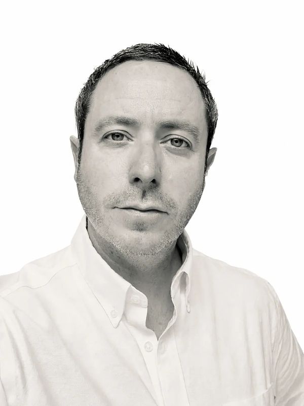 Black and white close-up portrait of a man with a serious expression.