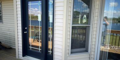 Glass doors and windows reflecting a lakeside view.