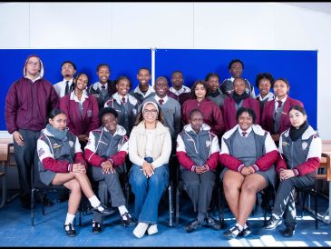 Group photo of diverse students with a teacher.
