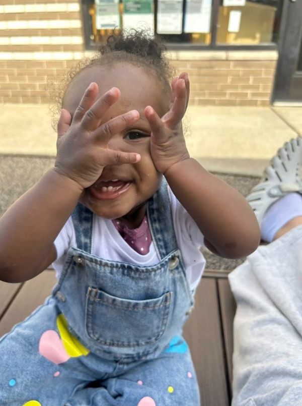 Happy baby playing peek-a-boo.
