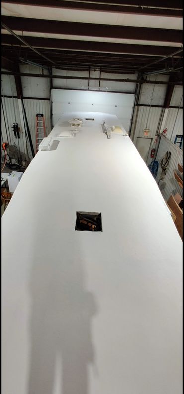 View of a white roof with vents inside an industrial building.