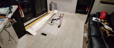 Room under renovation with exposed pipes and tools on the floor.