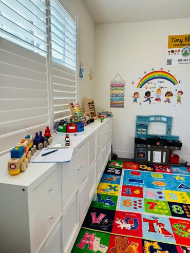 Bright and colorful daycare room with toys and educational decorations.
