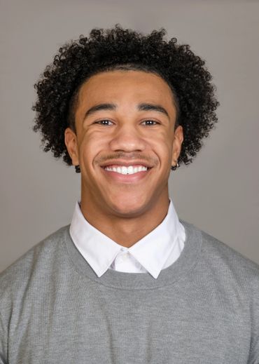young man curly black hair football studio portrait