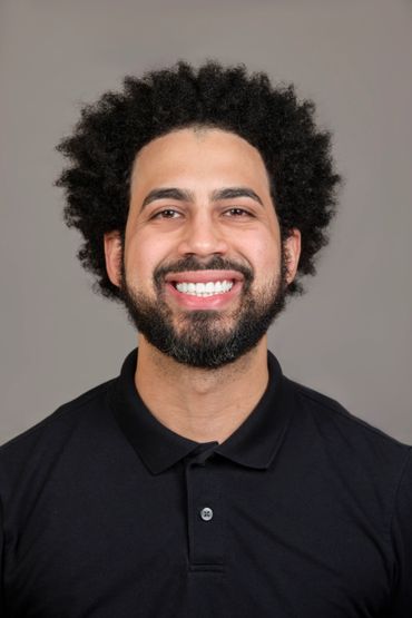 afro lightskin white teeth black polo shirt studio portrait