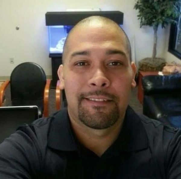 Man with a goatee smiling in an office setting.