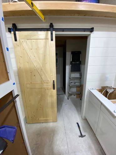 Stairs with lots of storage and refrigerator on the left, cabinets, sink, stove on the right