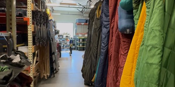 Cliff Creek Outfitters Warehouse full of neatly organized caping equipment- sleeping bags, tents.