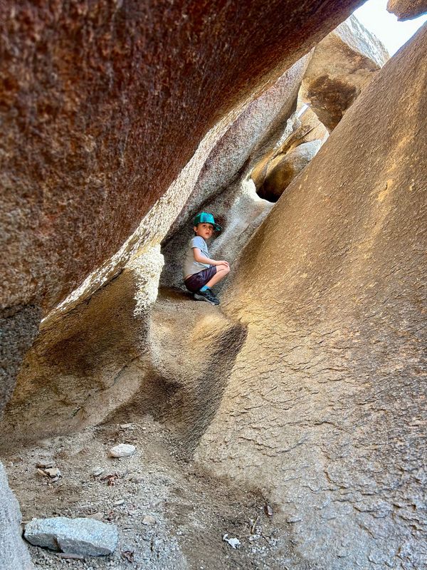 Small kid in between crevasse of giant boulders at Fat Man's Pass from Mormon Trail.