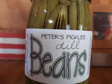 A jar of "Dill Beans" with a label that has a pickle logo.