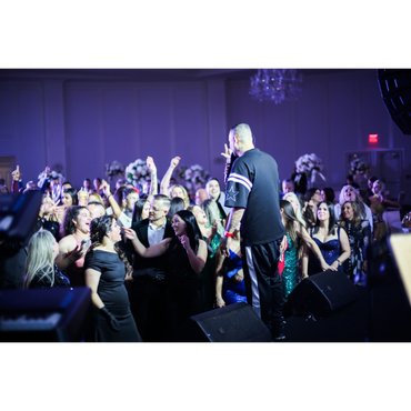 A lively crowd enjoying a performance with a singer on stage.