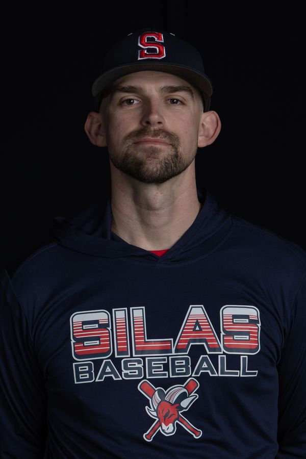 Man in a Silas Baseball hoodie and cap against black background.