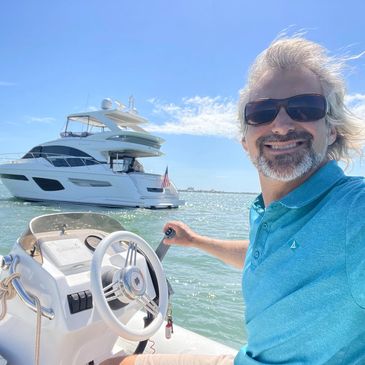 Captain Zac in the tender with a princess motor yacht in the background