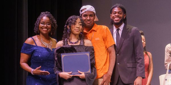 Group photo at an award ceremony with a diploma.