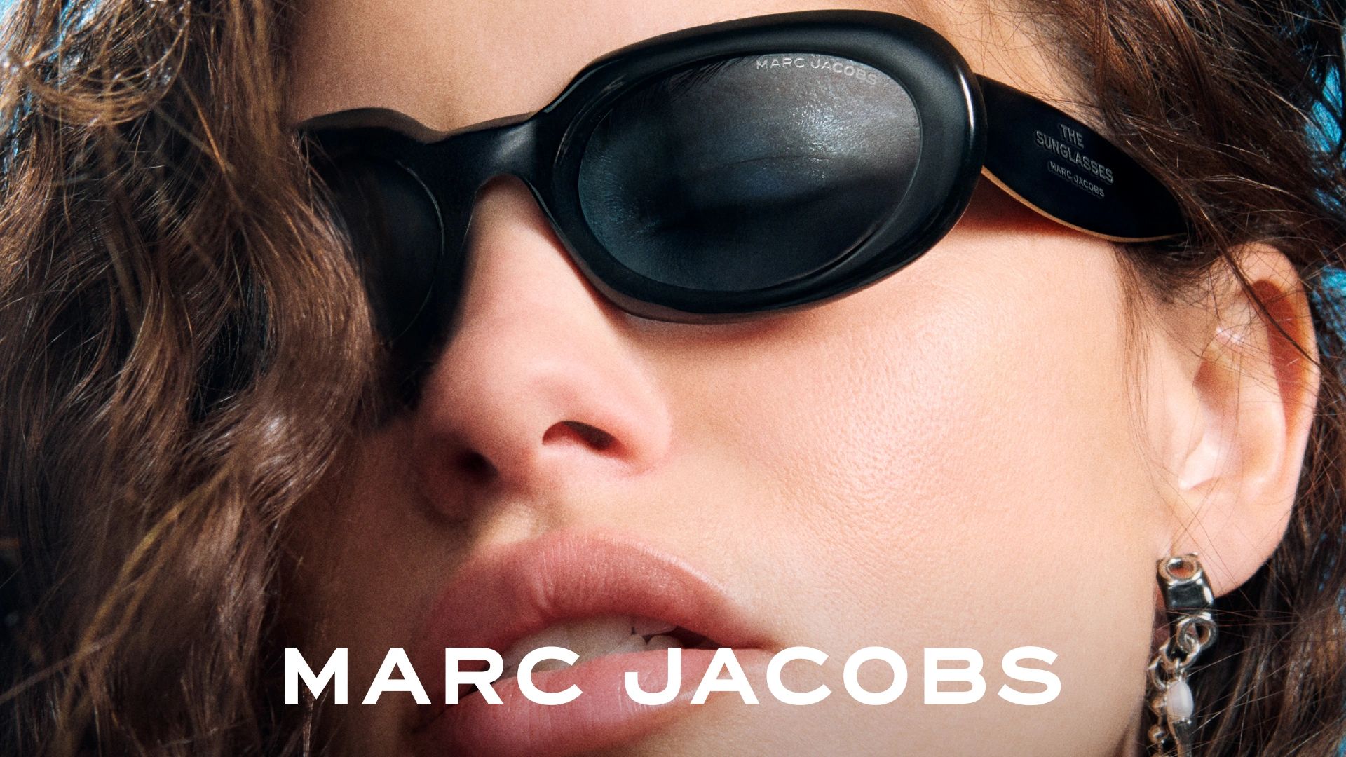 Close-up of a woman wearing black Marc Jacobs sunglasses.
