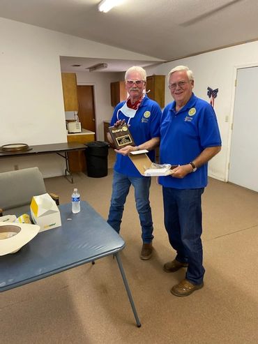 Bill Thedford presenting Dr. Gregory Bogard with a plaque recognizing 50 years of membership in Rota