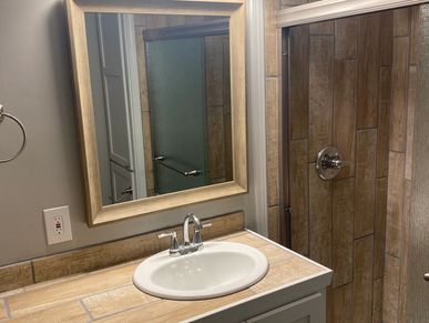 Bathroom remodel with wood look tile on counter and shower, new sink, shower pan, paint, and lights
