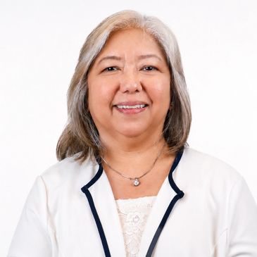 Smiling mature woman with gray hair in a white outfit.