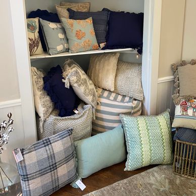 A cozy collection of decorative pillows arranged in shelves and on the floor.