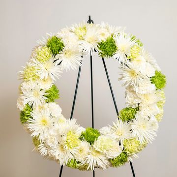 Green and white sympathy wreath with a mix of Chrysanthemum, carnations, and daisies