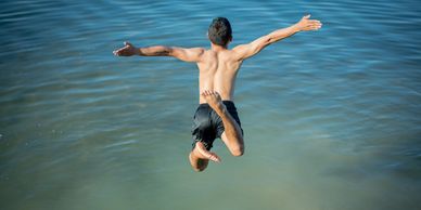 A man leaping with joy into water