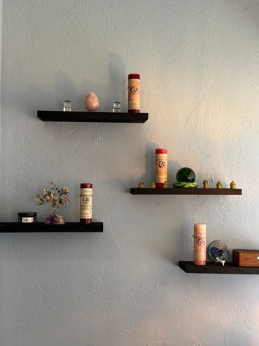 One of the walls inside Phoenix psychics Office with four shelves displaying metaphysical products