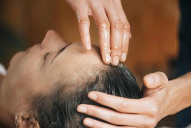 Person erhält eine Kopfmassage mit Öl.