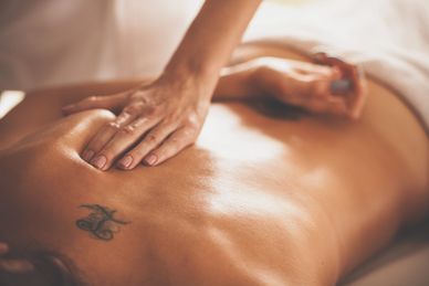Massage auf dem Rücken mit Tattoo.