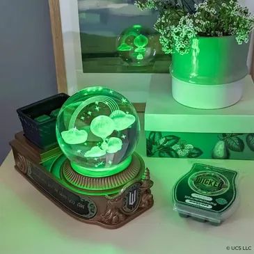 Scentsy scents of the season 2024 Wicked globe glows green on the desk.