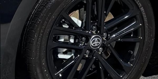Close-up of a black Toyota car wheel and tire.