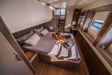 Cozy modern bedroom with breakfast tray and natural light from windows.