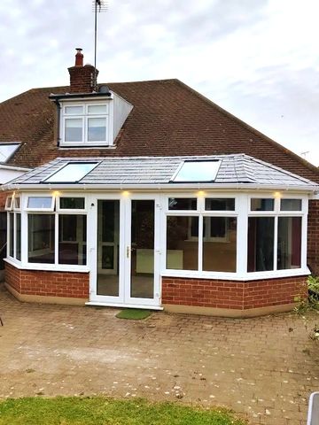 a brick conservatory with uPVC double glazed windows, a tiled SupaLite roof and two velux winows
